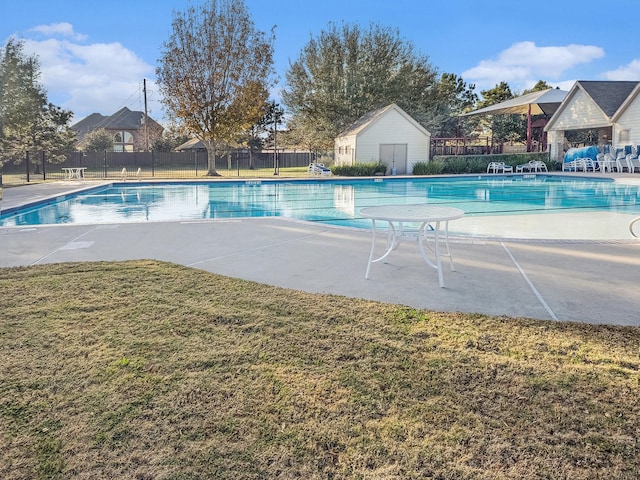 view of pool featuring a patio area and a yard