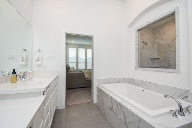 bathroom with vanity, tile patterned flooring, and a relaxing tiled tub