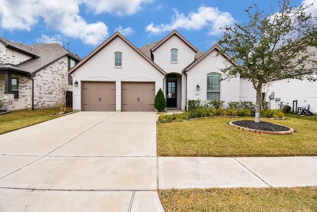 french country style house featuring a front lawn and a garage