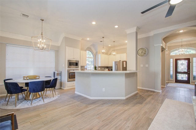 kitchen with light hardwood / wood-style floors, pendant lighting, decorative backsplash, stainless steel appliances, and white cabinets