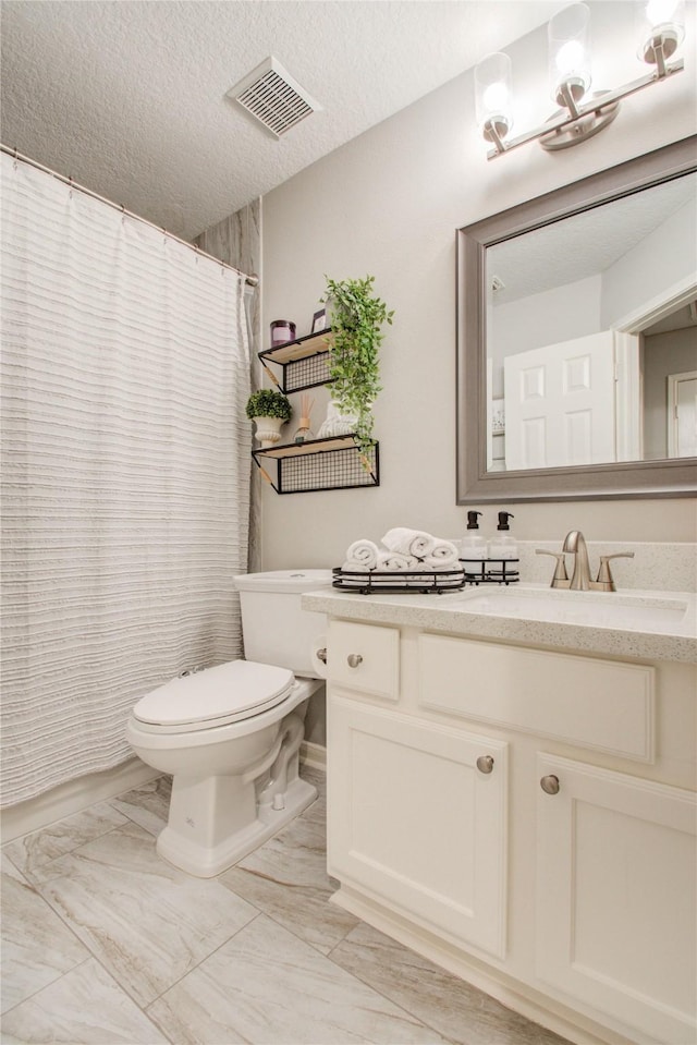 bathroom featuring toilet, vanity, and a textured ceiling