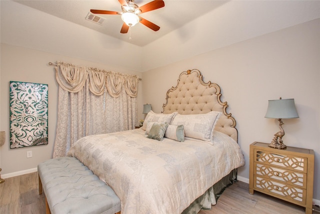 bedroom with ceiling fan, hardwood / wood-style floors, and lofted ceiling