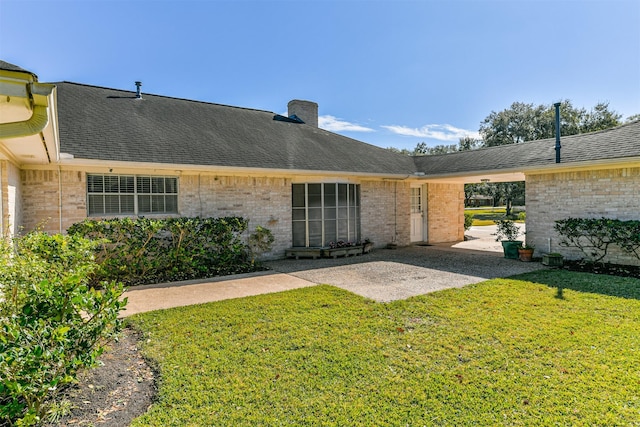 back of house featuring a patio area and a lawn