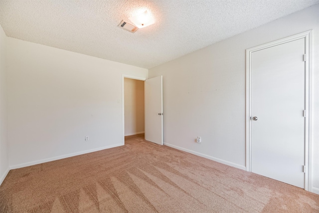 carpeted empty room featuring a textured ceiling