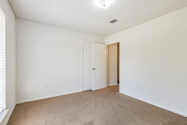 carpeted spare room featuring a textured ceiling