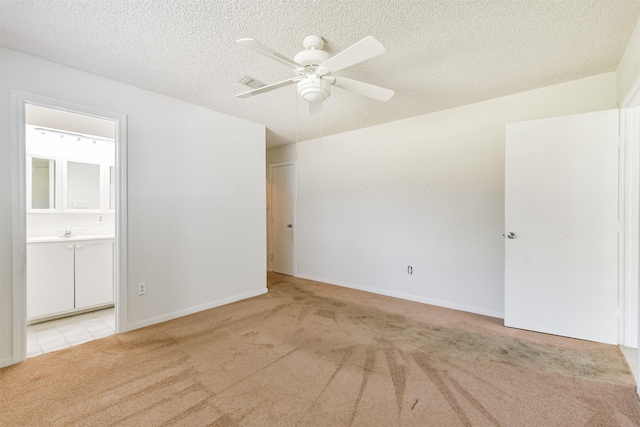 unfurnished room with ceiling fan, a textured ceiling, and light carpet