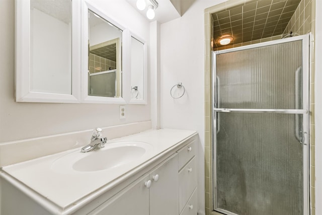 bathroom with a shower with shower door and vanity