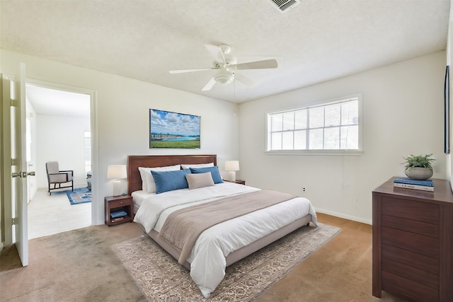 carpeted bedroom featuring a textured ceiling and ceiling fan