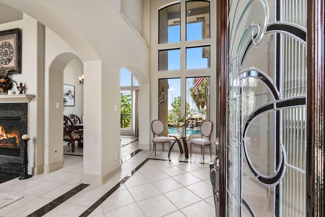 4 Mariners Ln, Kemah, TX 77565 - entrance foyer with a warm lit fireplace, baseboards, inlaid floor details, arched walkways, and a towering ceiling