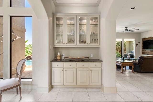 4 Mariners Ln, Kemah, TX 77565 - bar featuring arched walkways, light tile patterned flooring, ceiling fan, and baseboards