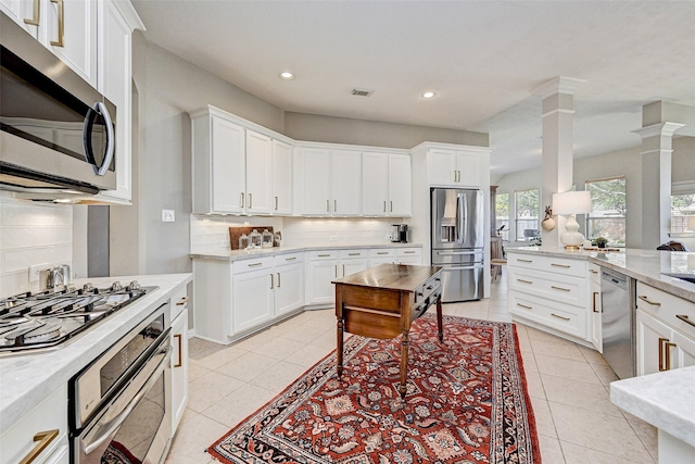 kitchen with backsplash, white cabinetry, appliances with stainless steel finishes, and ornate columns