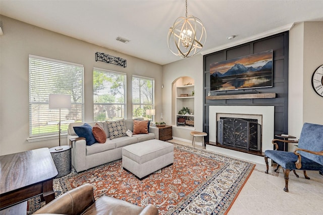 living room with built in features, an inviting chandelier, light tile patterned floors, and a large fireplace