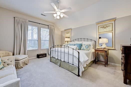 bedroom featuring light carpet, vaulted ceiling, and ceiling fan