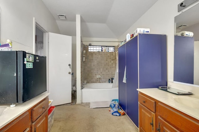 bathroom featuring vaulted ceiling, vanity, and shower / bathing tub combination