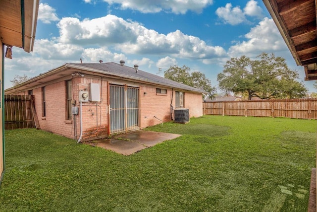 rear view of house featuring cooling unit and a yard