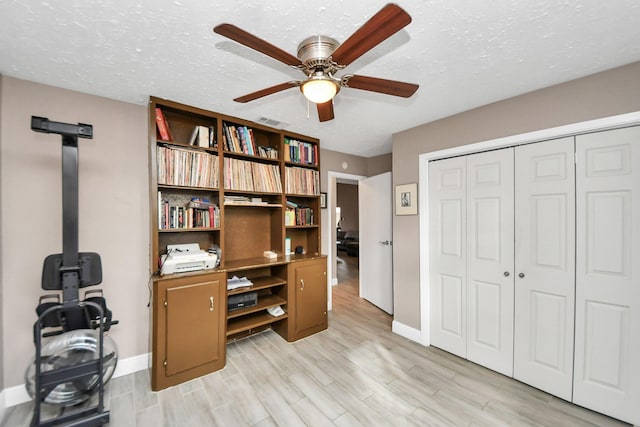 office area featuring ceiling fan, a textured ceiling, and light wood-type flooring