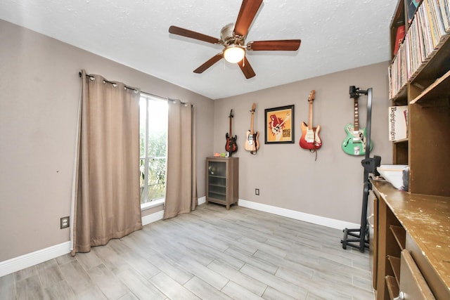 office featuring a textured ceiling, ceiling fan, and light hardwood / wood-style floors