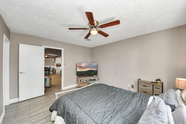 bedroom featuring ceiling fan and a textured ceiling