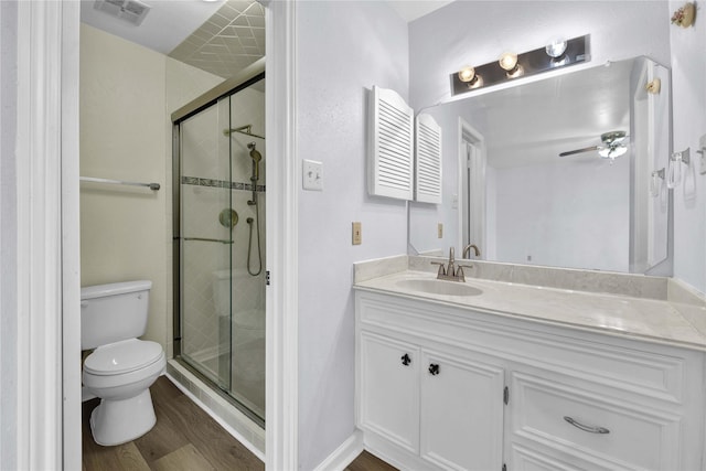 bathroom with toilet, vanity, a shower with door, and hardwood / wood-style flooring