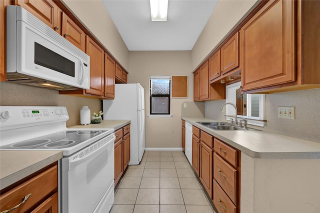 kitchen with light tile patterned floors, sink, and white appliances