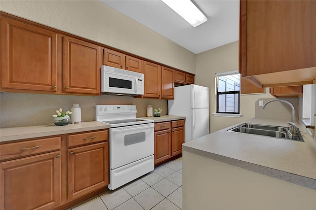 kitchen with light tile patterned flooring, sink, and white appliances