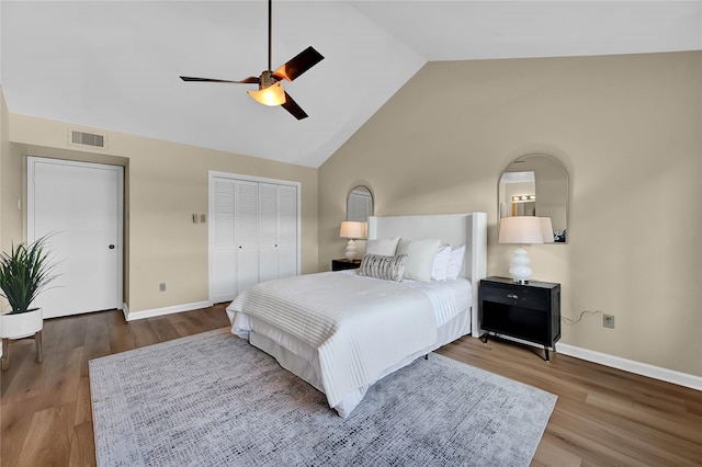 bedroom with ceiling fan, hardwood / wood-style floors, a closet, and high vaulted ceiling