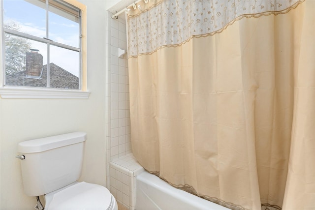 bathroom featuring shower / bath combo with shower curtain and toilet