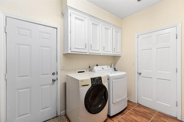 laundry area with cabinets and washer and clothes dryer