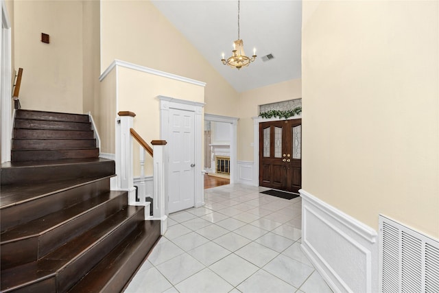 tiled entrance foyer with high vaulted ceiling and an inviting chandelier