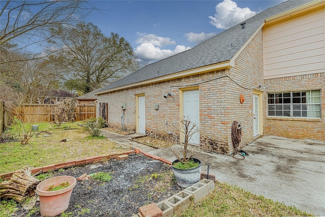 back of house with a patio area and a lawn