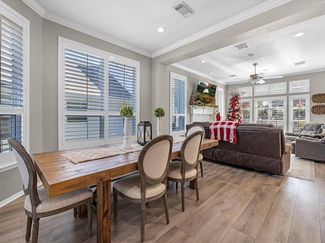 dining space with light hardwood / wood-style floors, crown molding, and ceiling fan