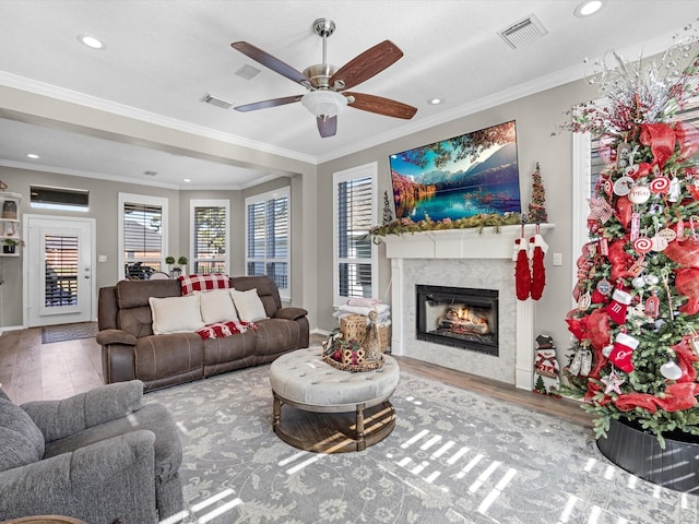 living room with ceiling fan, wood-type flooring, and ornamental molding