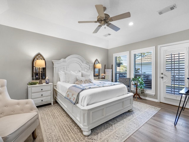 bedroom with ceiling fan, access to exterior, light hardwood / wood-style flooring, and multiple windows