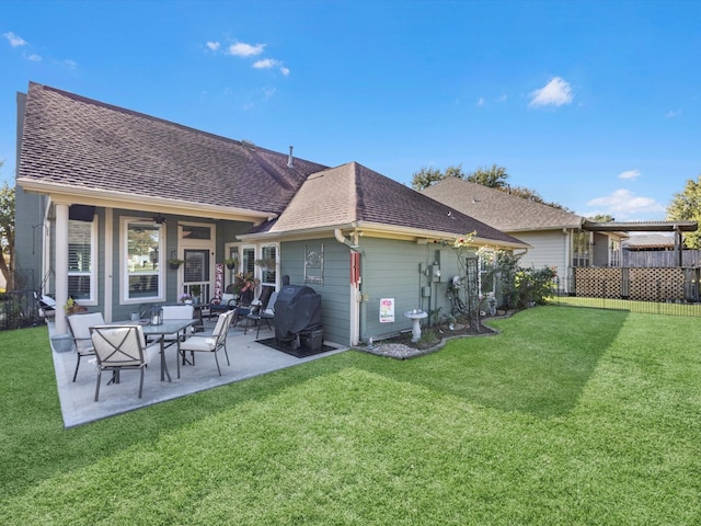 rear view of property featuring a yard and a patio