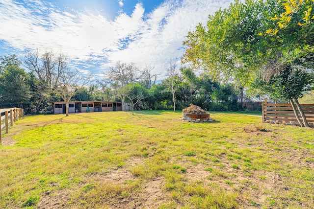 view of yard featuring an outbuilding and an outdoor fire pit