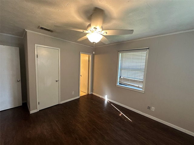 unfurnished bedroom with ceiling fan, ornamental molding, dark hardwood / wood-style flooring, and a textured ceiling