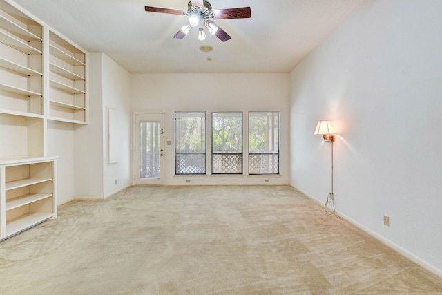 unfurnished living room featuring ceiling fan and light carpet