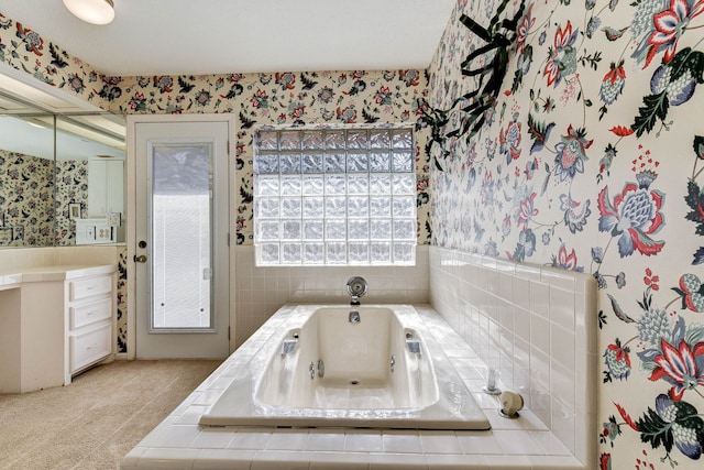 bathroom featuring tiled tub and vanity