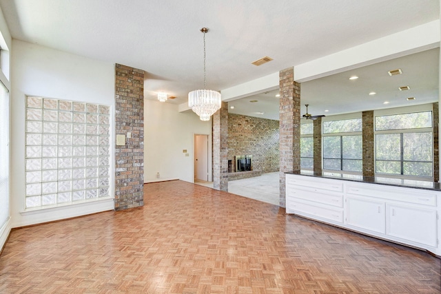 kitchen with a fireplace, white cabinetry, decorative light fixtures, ceiling fan, and light parquet flooring