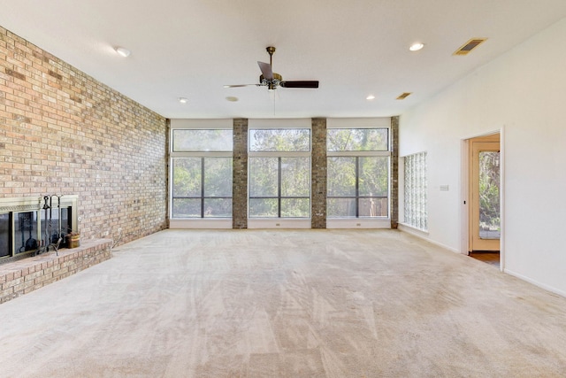 unfurnished living room featuring a fireplace, plenty of natural light, light colored carpet, and brick wall