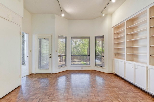 interior space featuring built in features, light parquet flooring, and a high ceiling