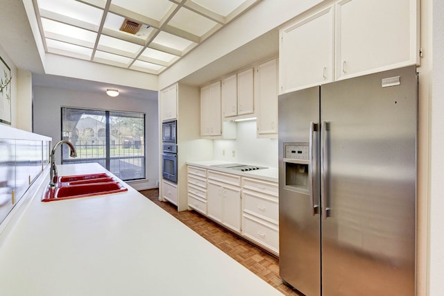 kitchen with black appliances, white cabinets, sink, and light parquet flooring