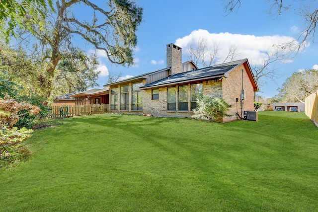 back of house featuring cooling unit and a lawn