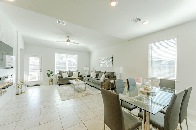 tiled dining space with ceiling fan and lofted ceiling