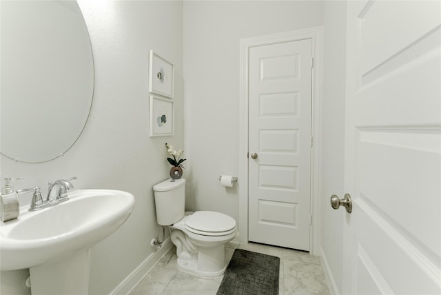 bathroom with sink, toilet, and tile patterned floors