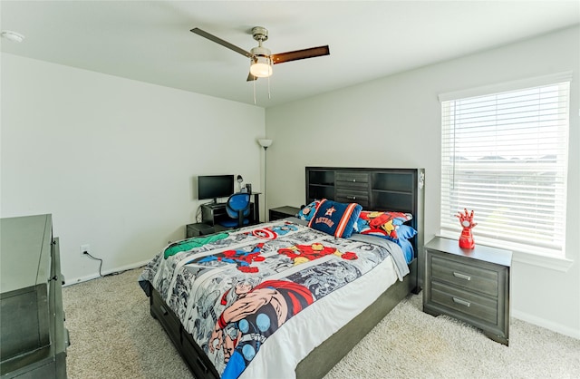 bedroom with ceiling fan, light carpet, and multiple windows