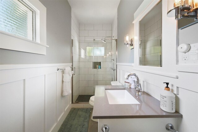 bathroom featuring vanity, toilet, a shower with door, and tile patterned flooring