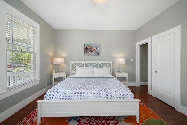 bedroom with dark wood-type flooring and multiple windows