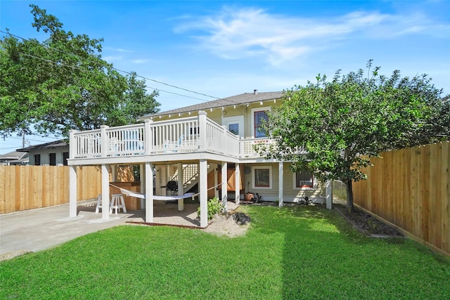 back of house with a patio, a lawn, and a wooden deck
