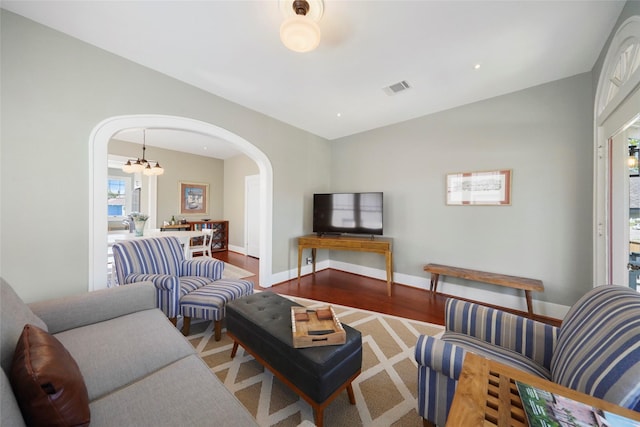 living room with hardwood / wood-style flooring and an inviting chandelier